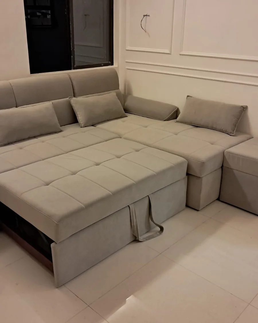 Beige sofa-cum-bed pulled out into a flat sleeping surface.