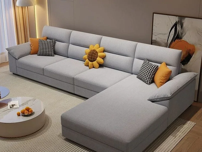 Light grey L-shape sofa with mustard cushions.